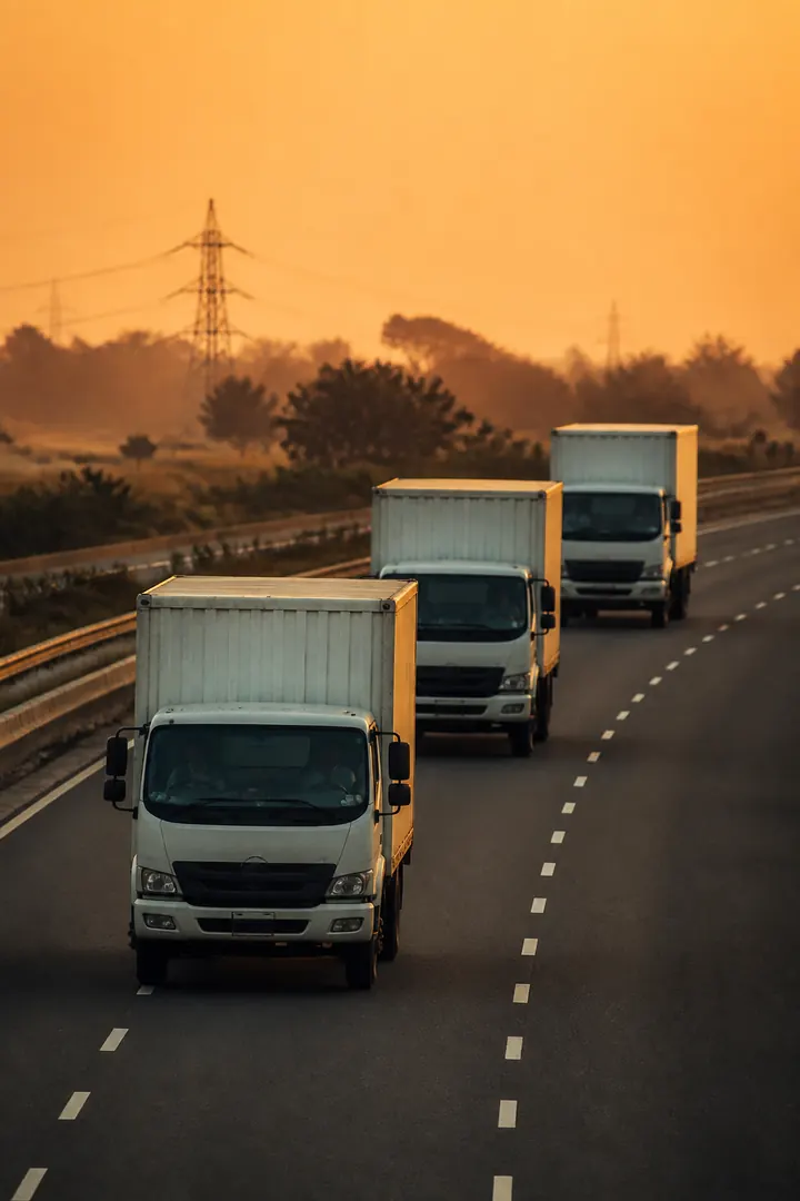 Box trucks on an expressway at golden hour
